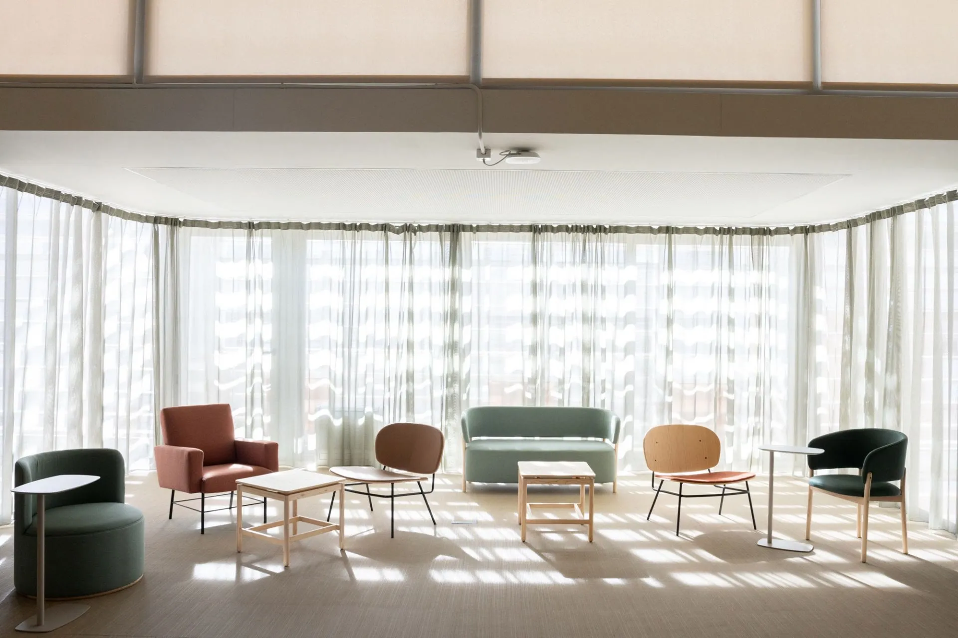 Atarazanas con sillones ante un ventanal con cortinas claras