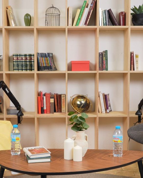 Dos anfitrionas grabando un podcast en Crisol, con estanterías de madera