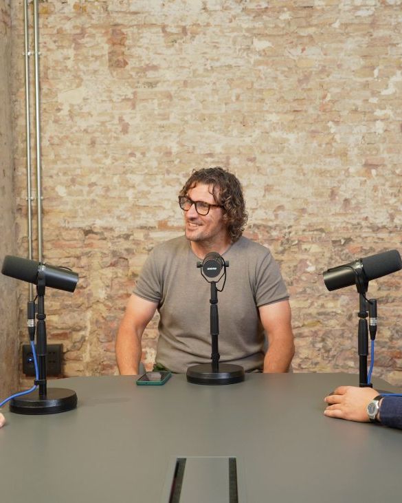 Three people recording around a table with microphones