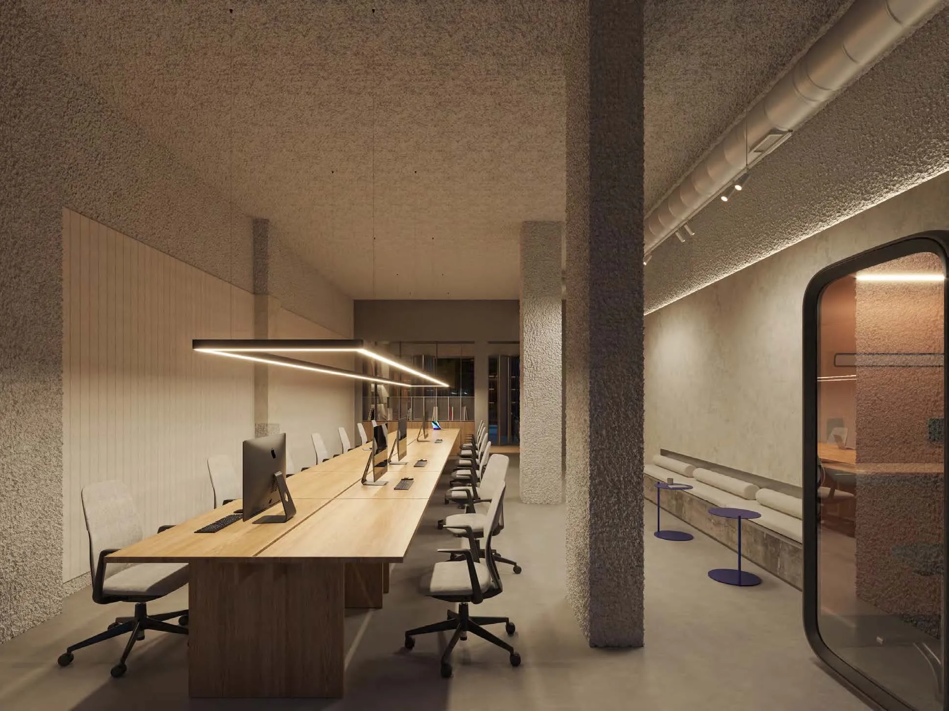 Visualización de la zona de coworking, con puestos a lo largo de una mesa de madera